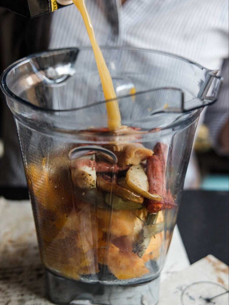 pouring vegetable broth into blender